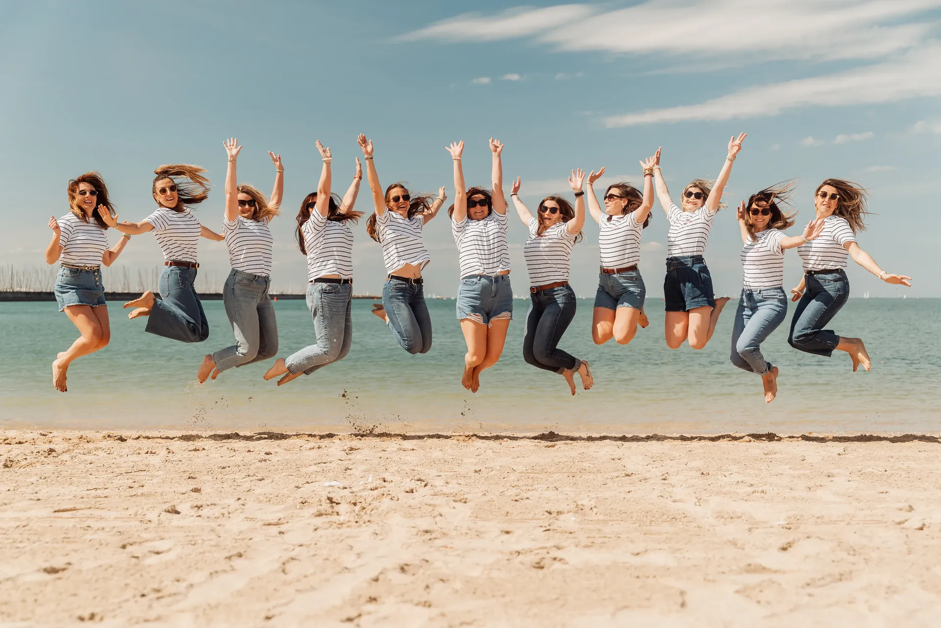 Groupe d'amies sautant sur la plage lors d'un shooting EVJF à La Rochelle, photographié par OJOStudio